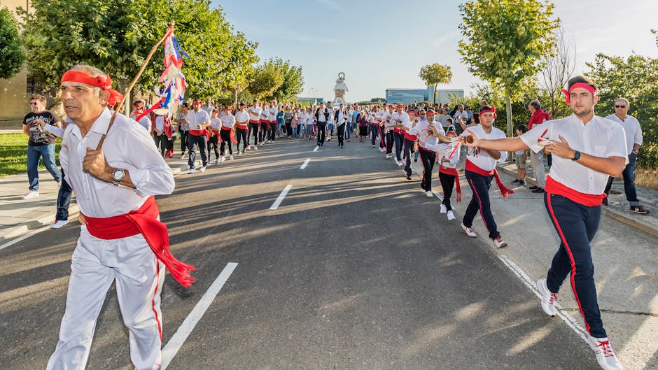 Optocht van dansers in witte kleding met rode banden tijdens feest op Rhodos