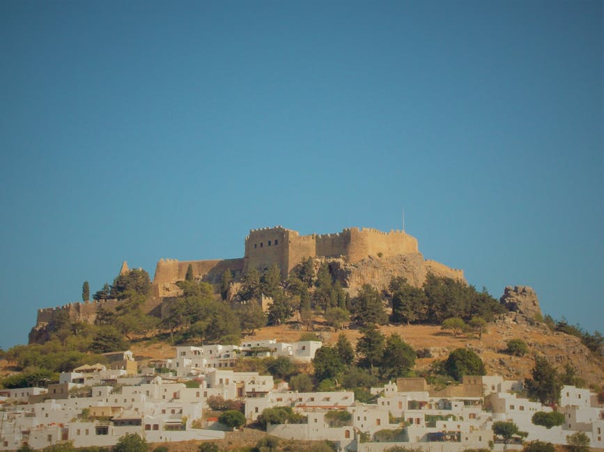 Burganlage auf einem Hügel über weißen Häusern in Rhodos
