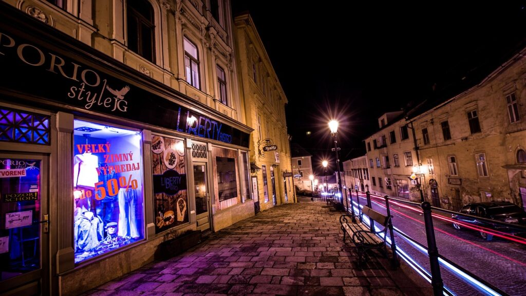 Vetrina illuminata e stradina acciottolata di sera a Rhodes