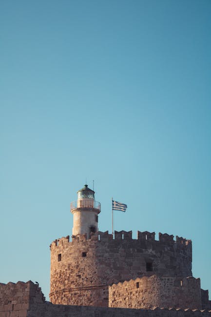 Tour fortifiée avec phare et drapeau grec, silhouette sur Rhodes