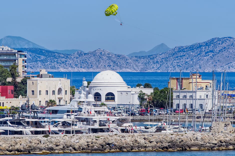 Parasailer above Rhodes marina with white domed building and yachts
