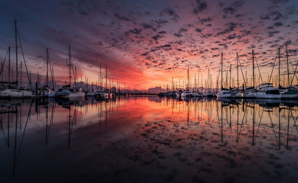 Yachthafen von Rhodos bei Sonnenuntergang, Segelboote spiegeln sich ruhig