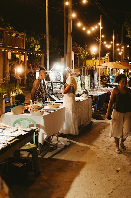 Bancarelle illuminate e visitatori che passeggiano al mercato notturno di Faliraki