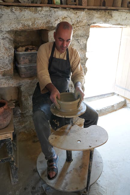 Potter shaping clay on a wheel inside a Rhodes pottery workshop