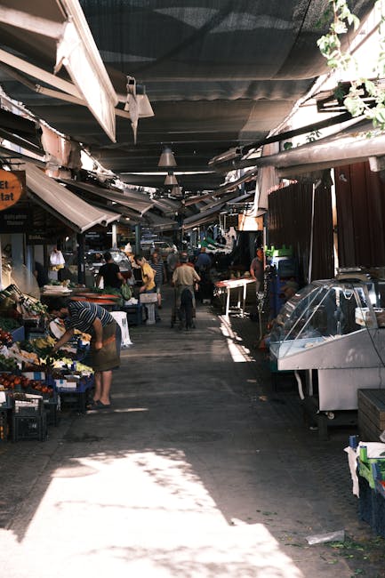 Shaded aisle inside Rhodes Central Market with vendors arranging produce