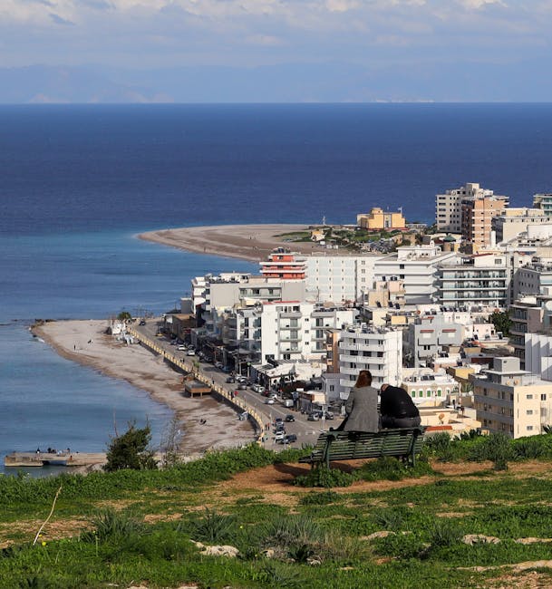 Deux personnes assises sur un banc face à la baie de Rhodes