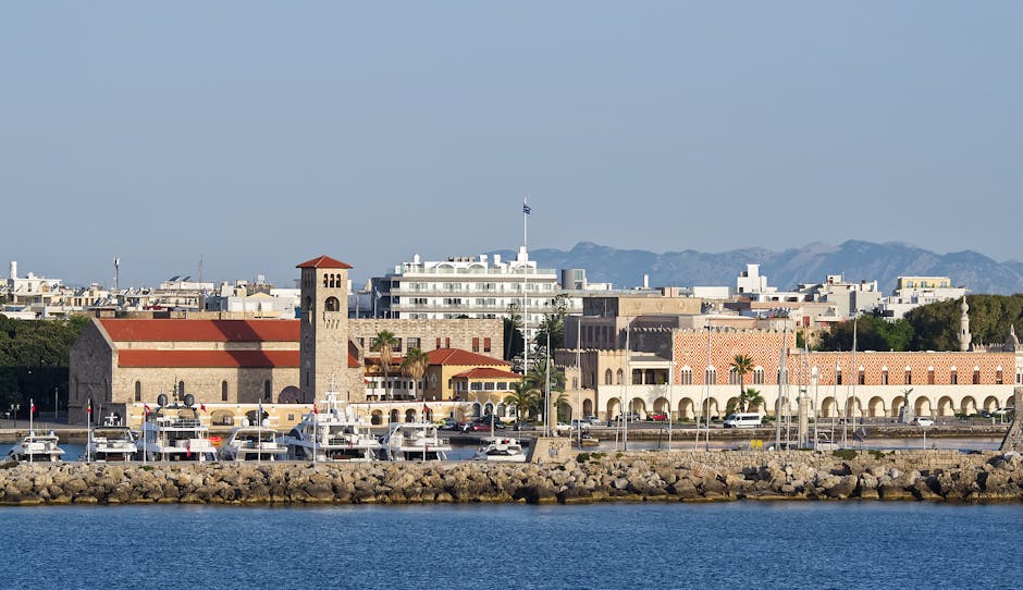 Rhodes waterfront with medieval tower, arched colonnade, and docked yachts