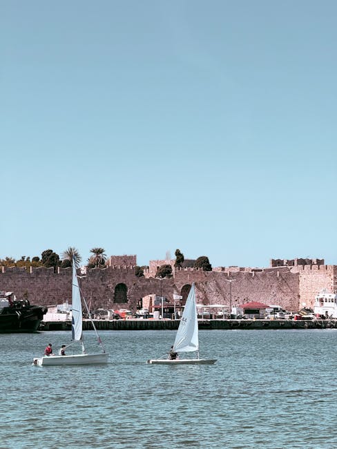 Kleine Segelboote im Hafen vor den historischen Stadtmauern von Rhodos