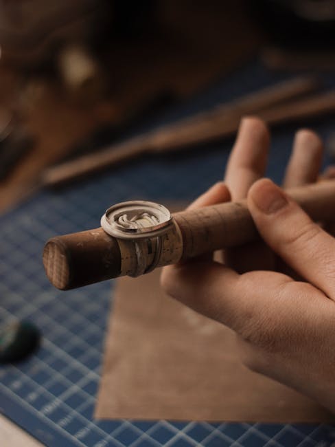 Mains d'artisan façonnant une bague sur un mandrin dans un atelier