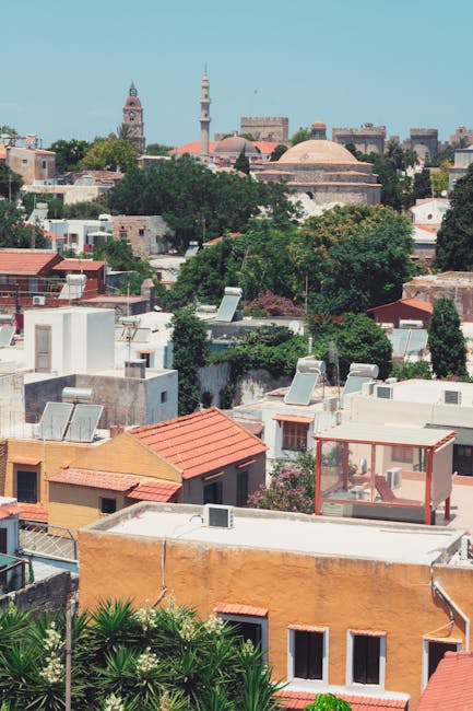 Tetti colorati e cupole della città vecchia di Rhodes tra alberi