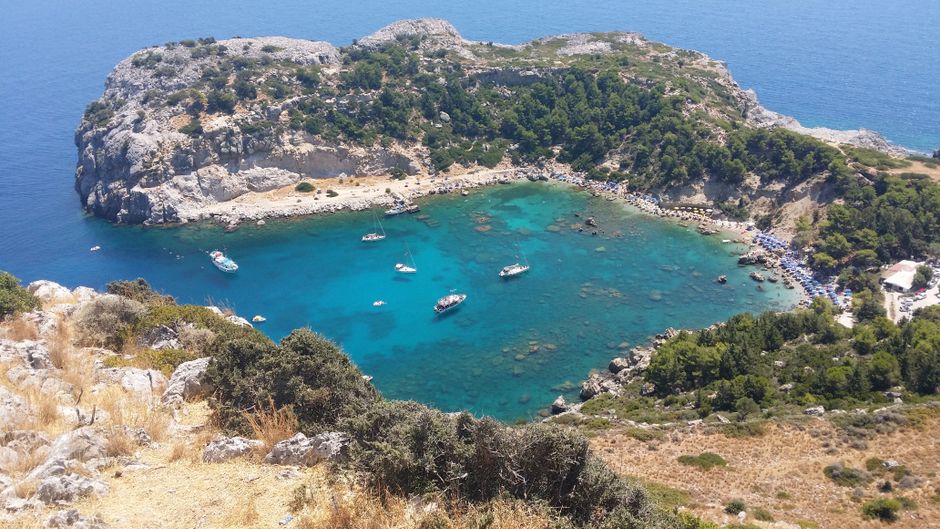Aerial view of a turquoise bay and rocky peninsula in Rhodes