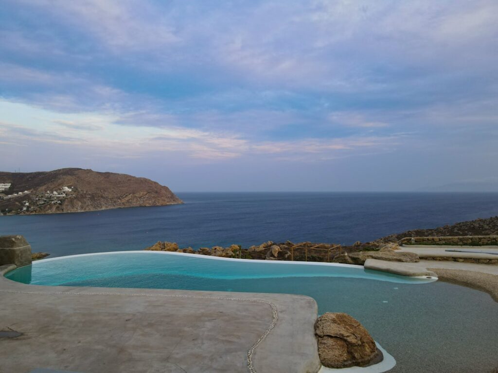 piscine à débordement face à la mer de Mykonos au crépuscule