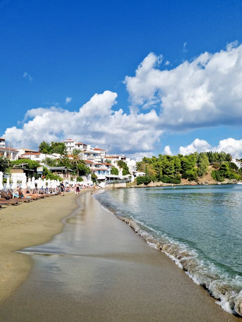 Plage de sable avec parasols et maisons, côte de Mykonos