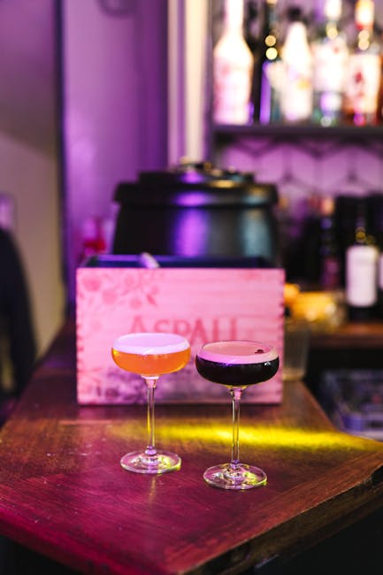 Deux cocktails sur comptoir bar violet, ambiance nocturne en club de Mykonos.