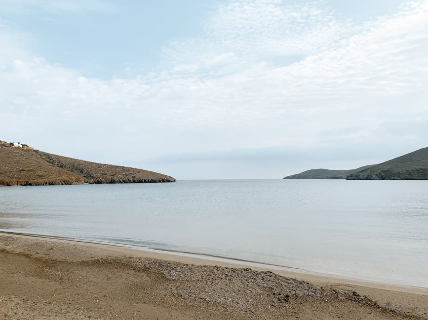 Beschutte baai met kalm water en lage heuvels aan de kust van Mykonos