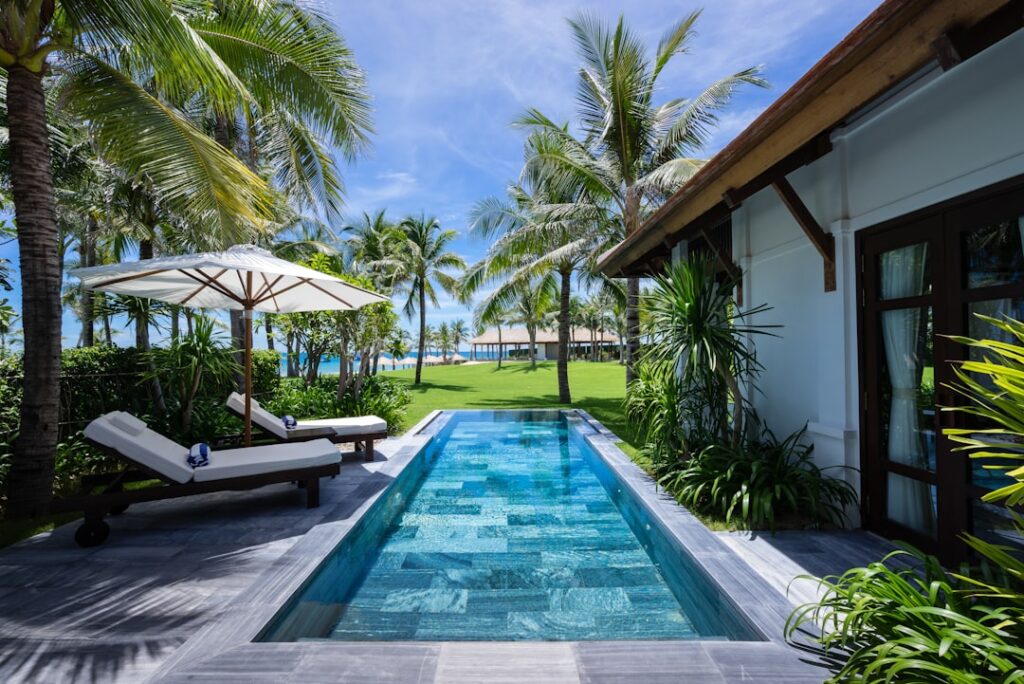 Villa privée avec piscine étroite, transats et palmiers luxuriants