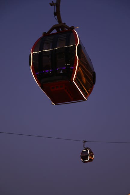 Illuminated cable car cabins suspended across twilight sky