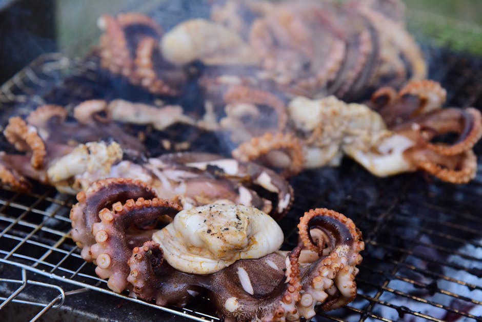 Gegrilde octopussen met knapperige tentakels op rooster boven houtskool op Mykonos