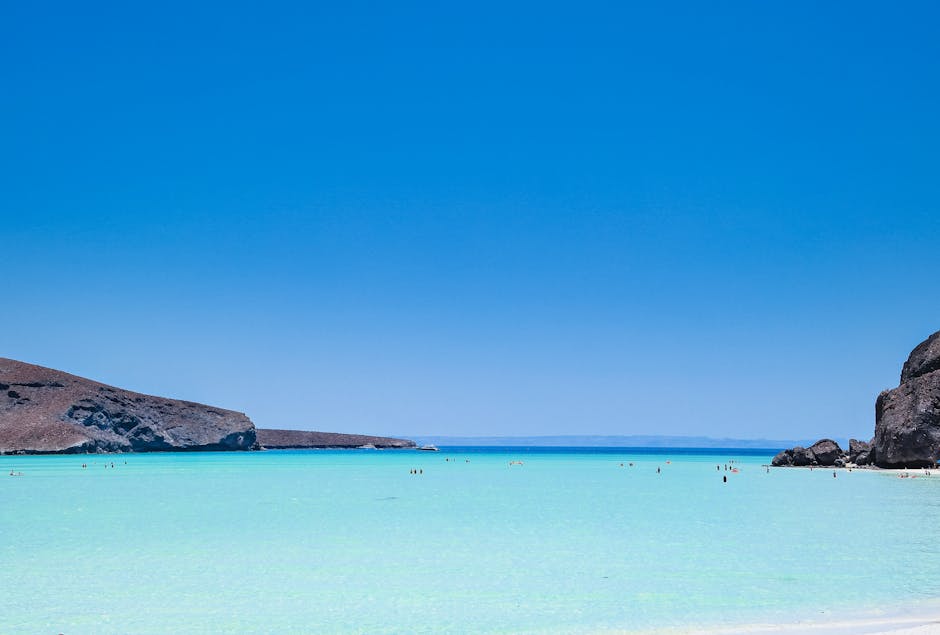 Kristalhelder turquoise water en zwemmers in ondiepe zee van Mykonos