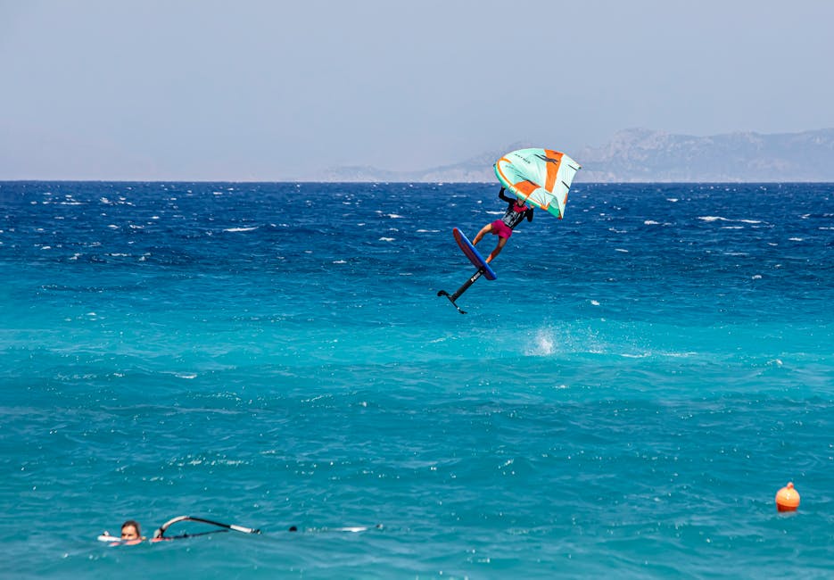 Wingfoiler in sprong met kleurrijke wing boven turquoise water bij Mykonos