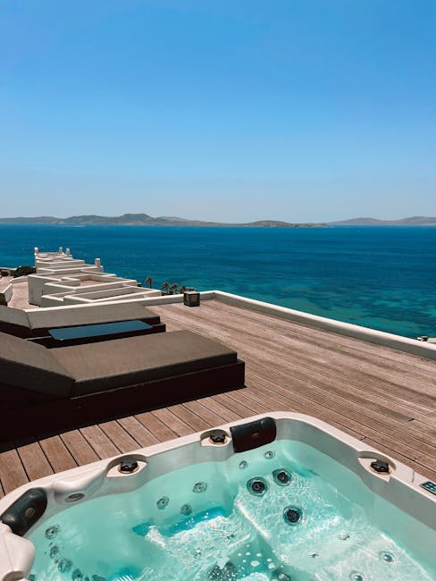 Rooftop jacuzzi and dark sunbeds facing turquoise Aegean near Mykonos.