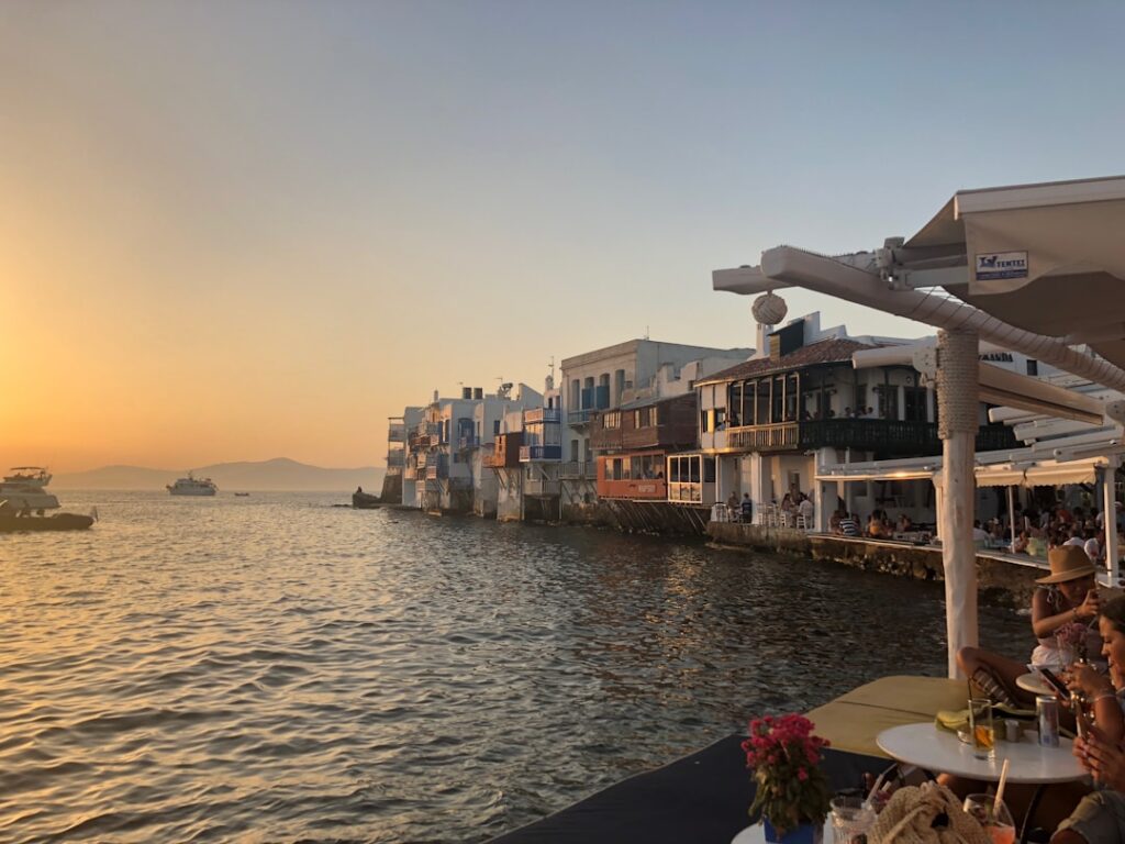 Zonsondergang boven waterfront met terrassen en witte huizen van Mykonos