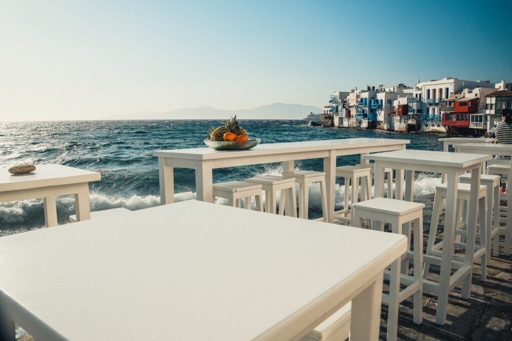 Tables blanches au bord de l'eau vue sur Little Venice à Mykonos