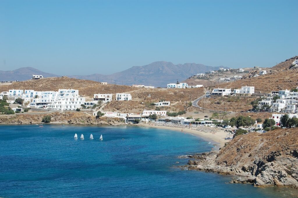 Kustbaai met kleine zeilbootjes en stranden bij Mykonos