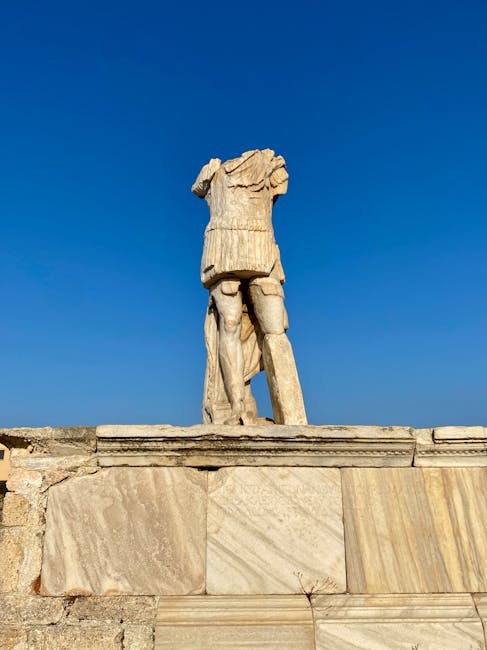 Torse de statue antique sans tête posé sur un mur à Délos