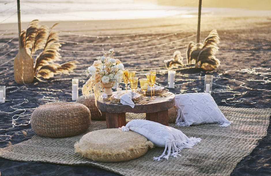 Sfeervolle strandpicknick met kussens en laag tafeltje bij zonsondergang Mykonos