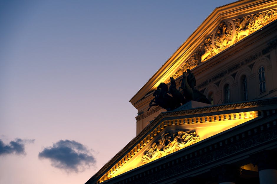 Fronton orné sculpté d'un quadrige illuminé au crépuscule.