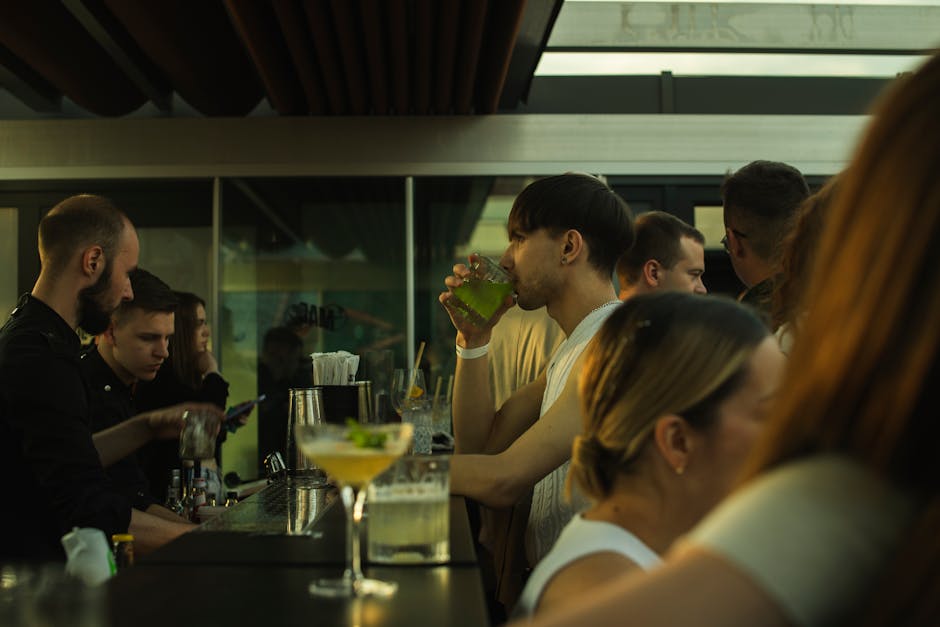 Mensen aan de bar drinken cocktails in een drukke club op Mykonos