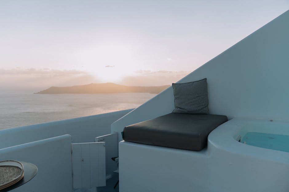Witte Mykonos-terrasbank naast privé jacuzzi met zonsondergang boven zee