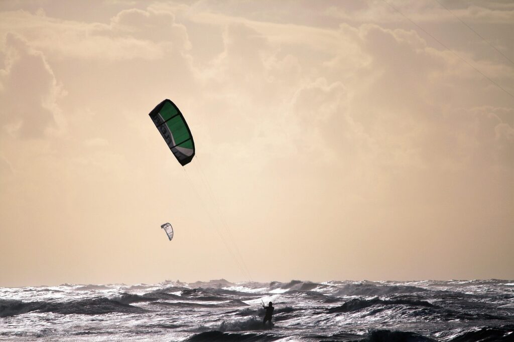 Kitesurfeur silhouetté sur vagues agitées au large de Mykonos
