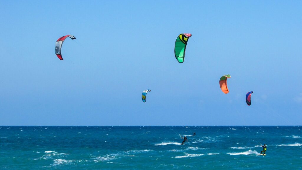 Kitesurfeurs glissant sur l'eau turquoise de Mykonos sous voiles colorées