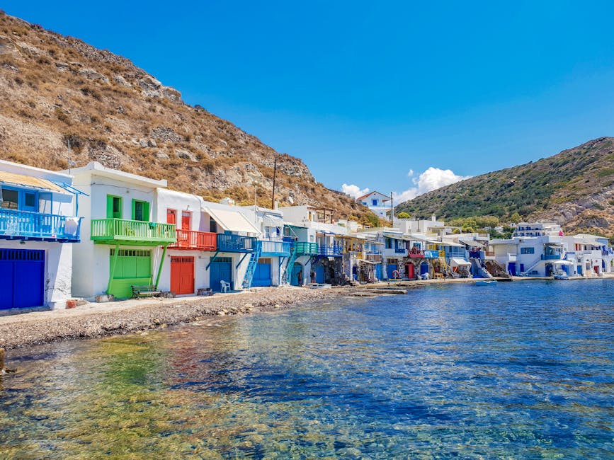 Colorful beachfront boathouses with balconies along Mykonos rocky shore
