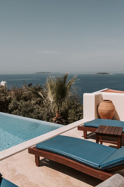 Chaises longues bleues près d'une piscine à débordement avec vue sur la mer de Mykonos