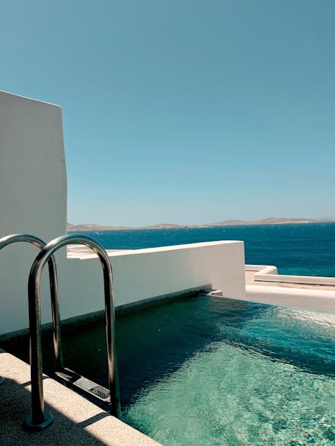 Petite piscine avec échelle métallique et horizon marin depuis une terrasse à Mykonos