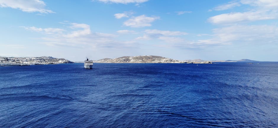 Ferry s'approchant des côtes de Mykonos, mer bleu profond et horizon