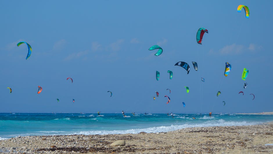 Kitesurfeurs nombreux au large d'une plage de Mykonos, voiles colorées