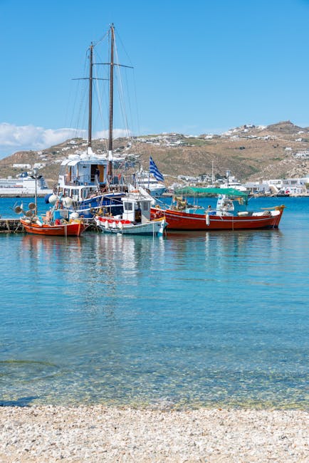 Kleurige boten in de haven van Mykonos met Griekse vlag