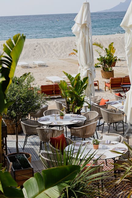 Lege tafels en parasols bij een chique strandrestaurant op Mykonos