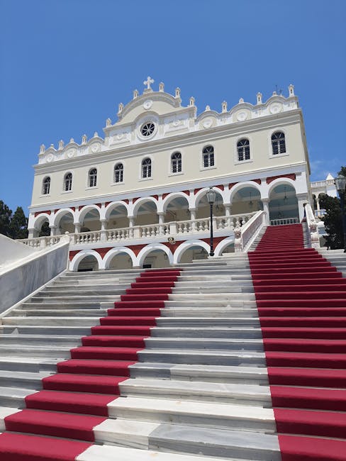 Escalier en marbre avec tapis rouges menant à une église blanche à Mykonos