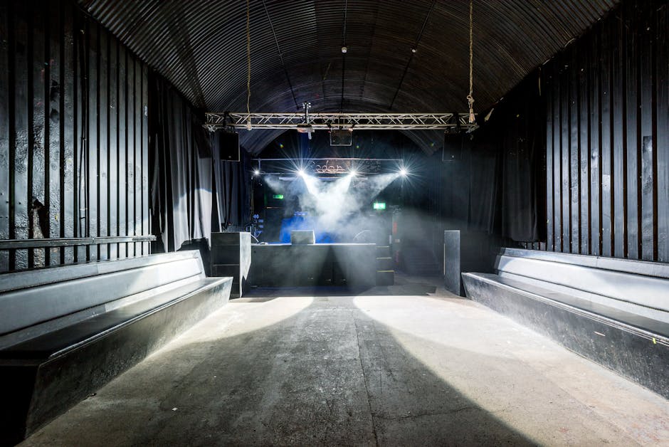 Donkere clubzaal met podium en lichteffecten, klaar voor Mykonos-feest