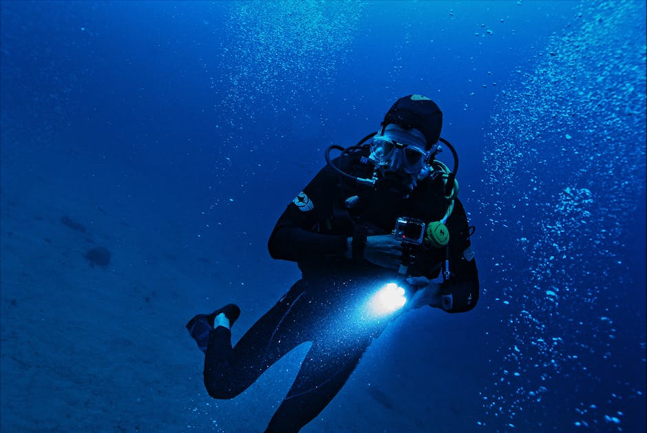 Plongeur nocturne éclairant les eaux profondes, bulles montant vers la surface
