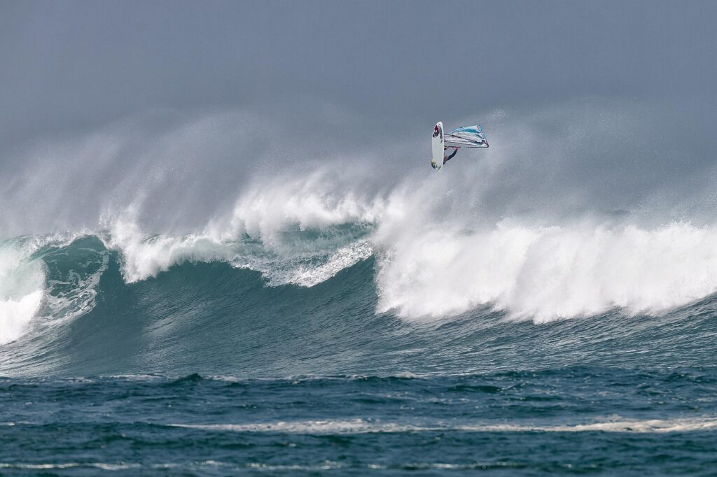 Windsurfer en plein saut au-dessus d'une grosse vague près de Mykonos