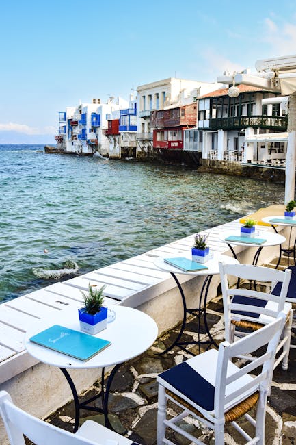 Gezette tafels en stoelen aan zeekant met Little Venice Mykonos