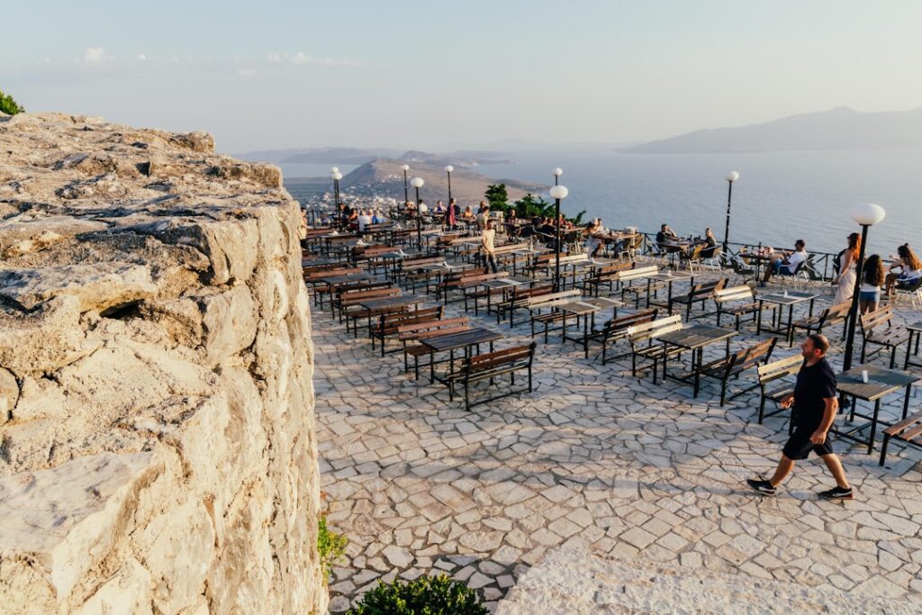 Groot terras met rijen tafels en uitzicht over Mykonos zee