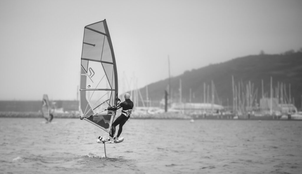Windsurfer en foil naviguant devant la marina de Mykonos