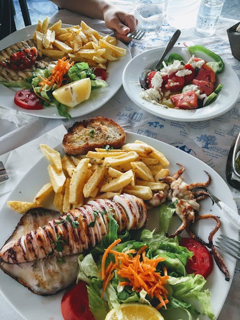 Bord met gegrilde inktvis, frietjes en Griekse salade in Mykonos